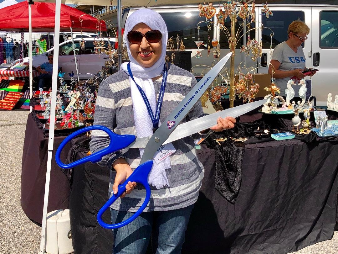 Femy Aziz with ceremonial scissors at Merrick Chamber event