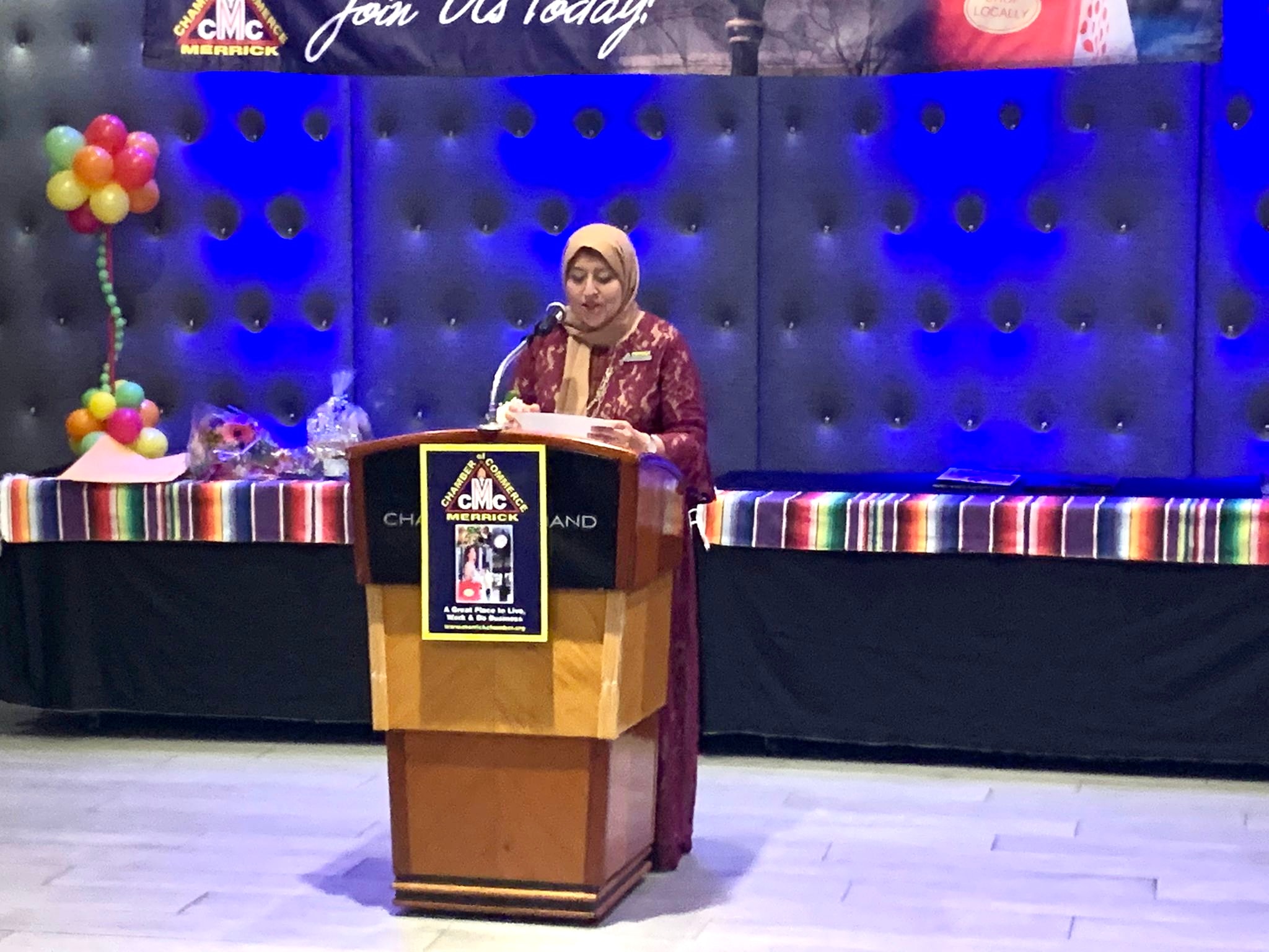 Femy Aziz speaking at podium at Chamber event
