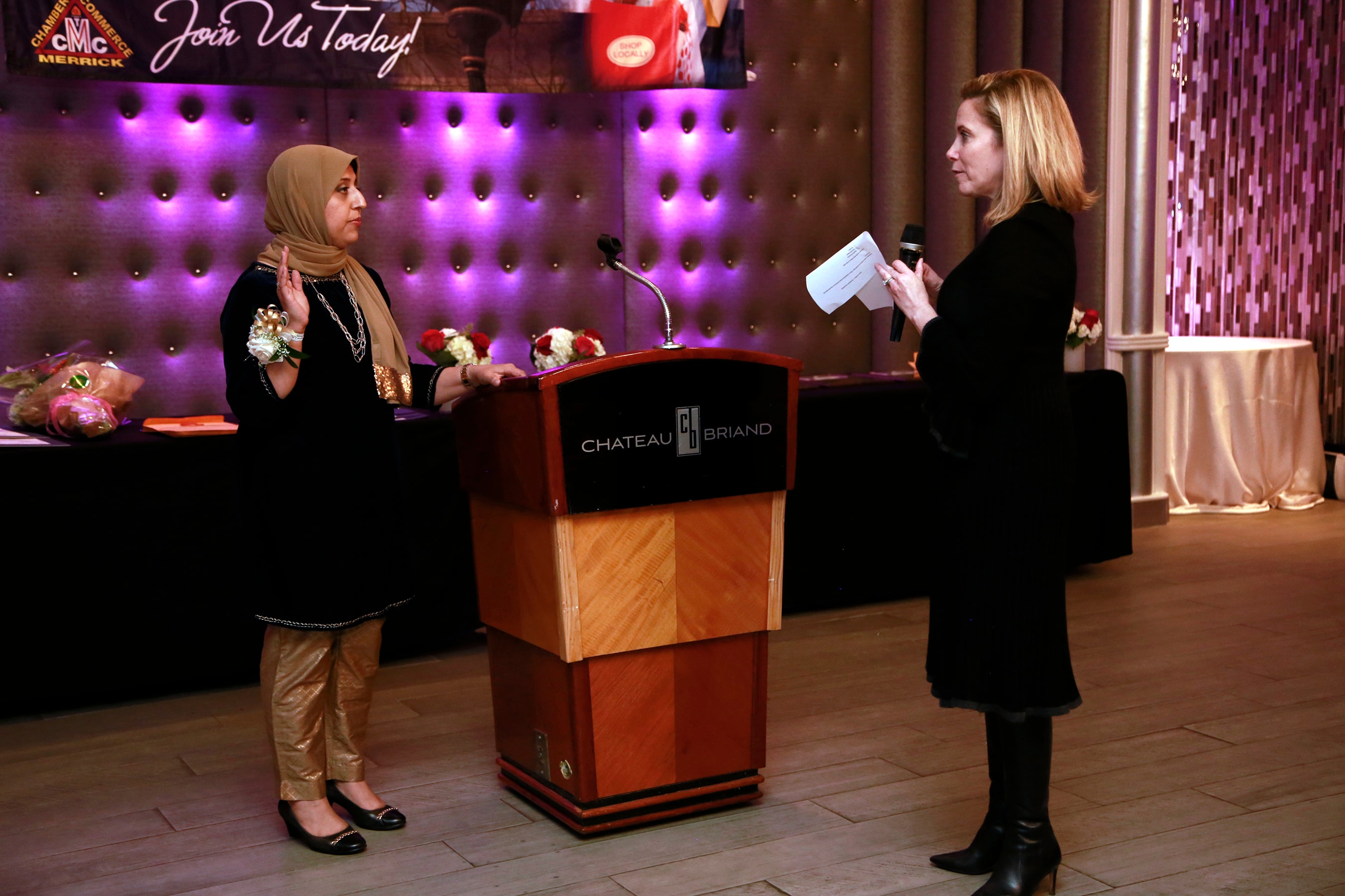 Femy Aziz speaking at podium at Chateau Briand